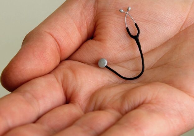 Hand holding a tiny stethoscope