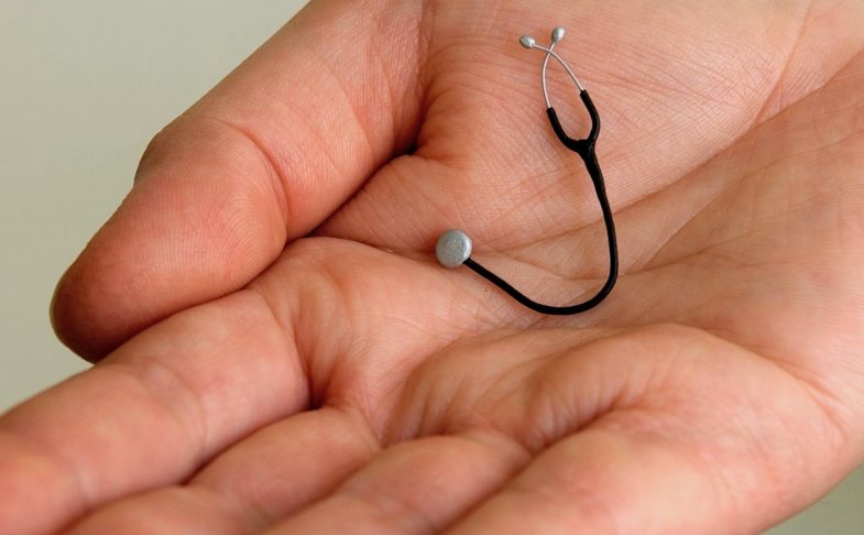 Hand holding a tiny stethoscope