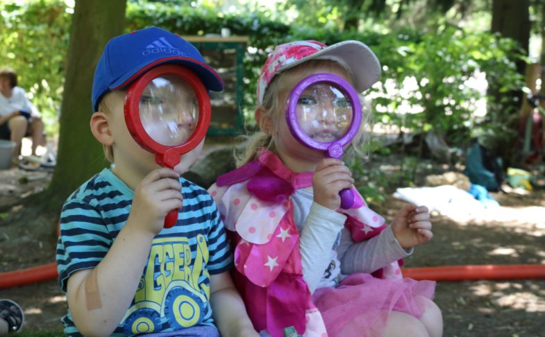 Little explorer at YPS, two children with large magnifying glasses in front of their faces