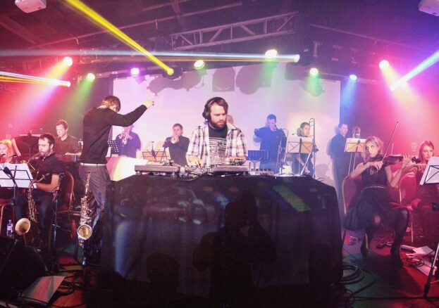 RNCM Young Explorers event. DJ Switch is shown by turntables in front of an orchestra. Included in family things to do guide.