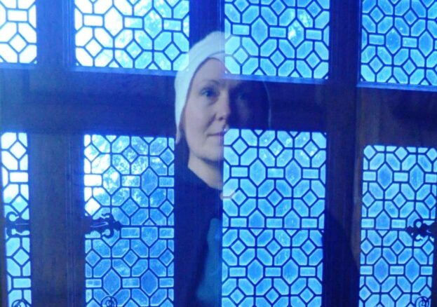 Hallowtide activities at Little Moreton Hall. Woman's reflection shown in a window.