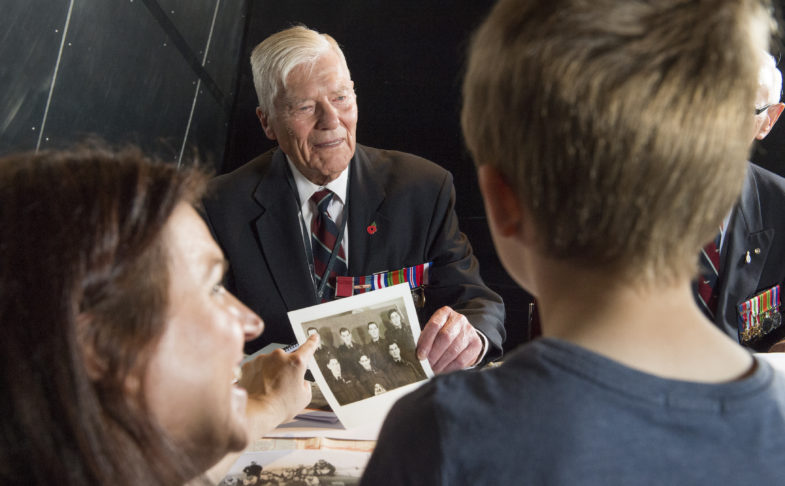 A young boy and a woman meet a veteran in the meet the veterans event at IWMN