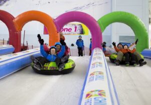 People sliding down the slopes at Chill Factore on an inflatable ring