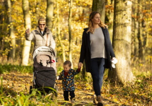 A family walking along a path in the woodlands trail at Lyme Park.