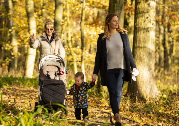 A family walking along a path in the woodlands trail at Lyme Park.