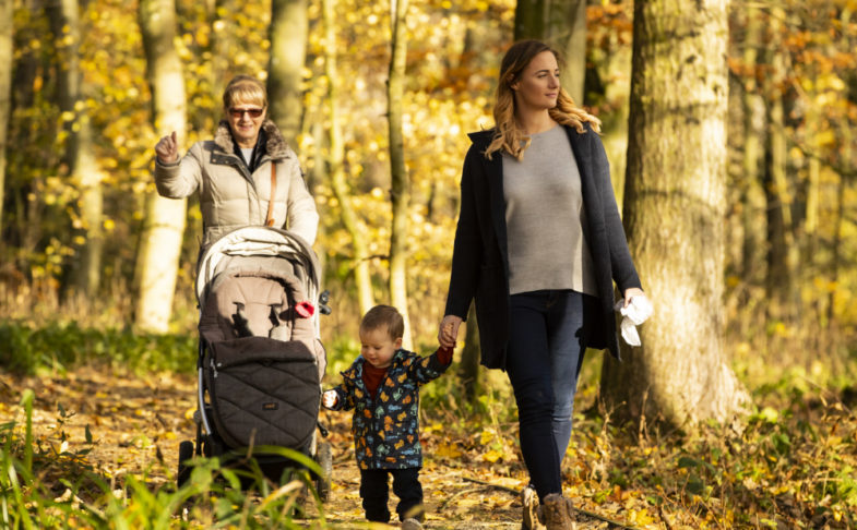 A family walking along a path in the woodlands trail at Lyme Park.
