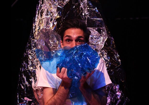 Man holding shiny materials, part of the set for Glisten