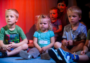 Children sat on the floor for Under the Rainbow activity