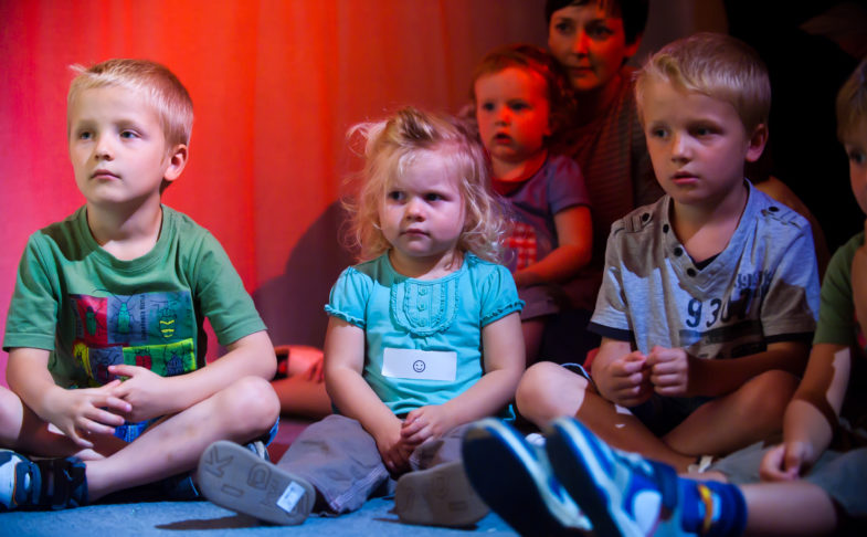 Children sat on the floor for Under the Rainbow activity