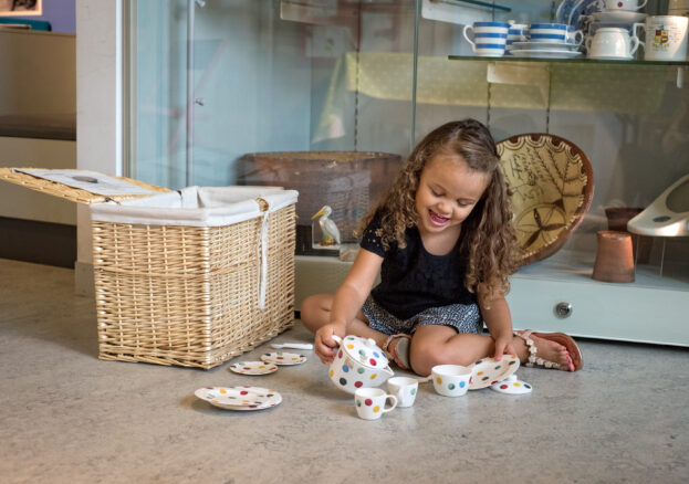 Young girl playing with a tea set at Toddler Tuesdays