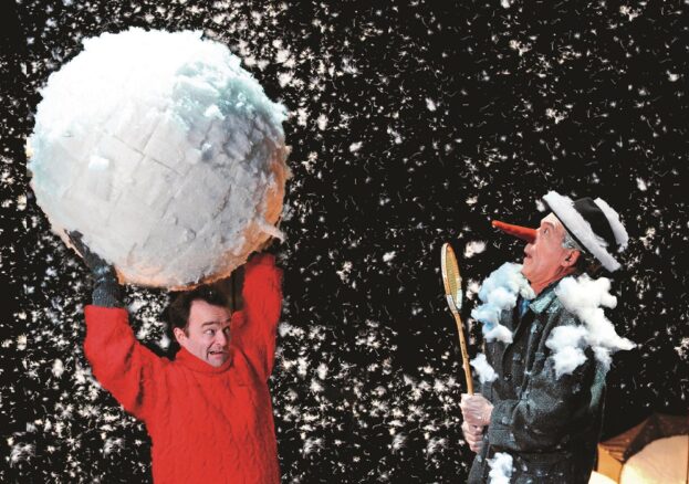 Man holding a giant snow ball above his head in Snow Play