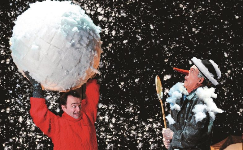 Man holding a giant snow ball above his head in Snow Play