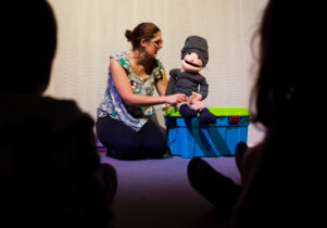 Mr Ordinary's Prize - Lady knelt on the floor with a puppet