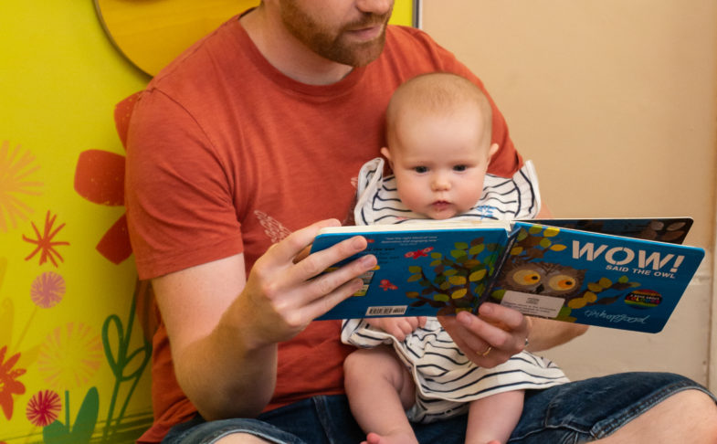 Man reading to baby in Wow said the Owl exhibition