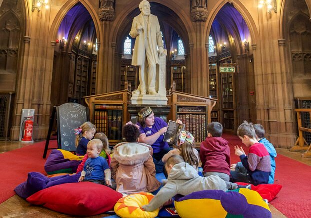 Children sat on cushions in Toddler Tales session