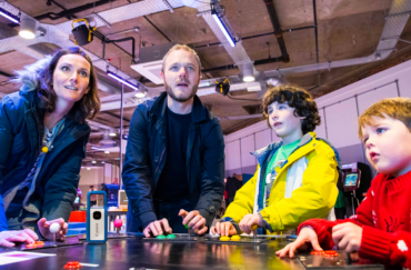 A family enjoying gaming together at the National Videogame Museum.