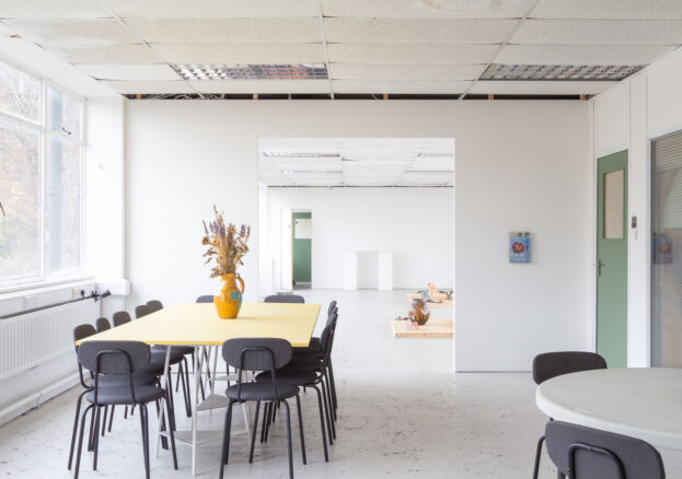 View of PINK meeting area and exhibition space, with a table, chairs and white walls