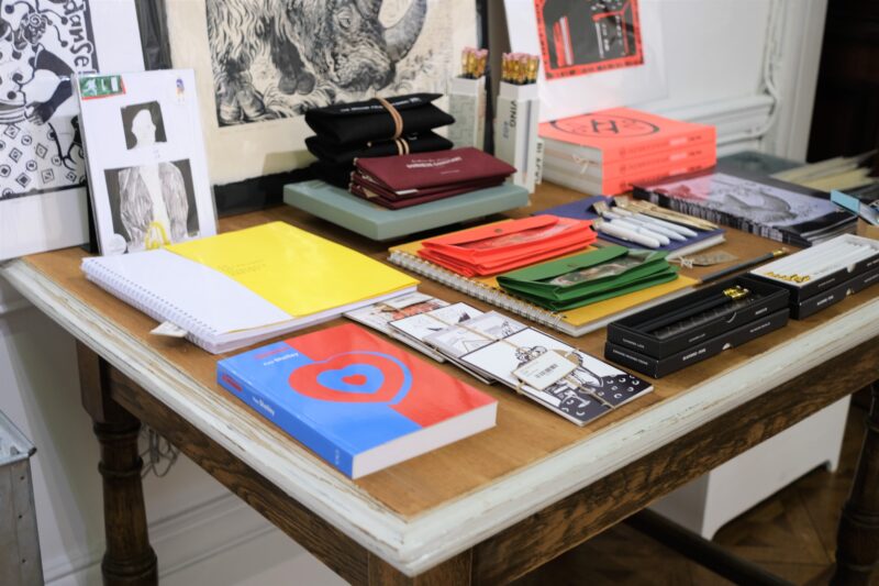 Books and pencils layed out on a wooden table at the Bury Art Shop