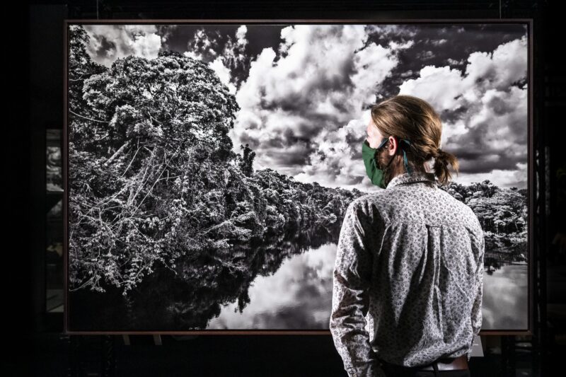 Woman looking at photograph in Amazonia exhibition at Science and Industry Museum Manchester