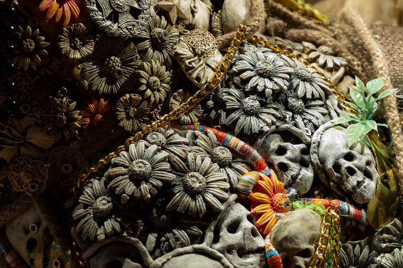 Hew Locke, The Ambassadors. Detail of installation, depicting daisies alongside skulls adorned with leaves and a gold chain