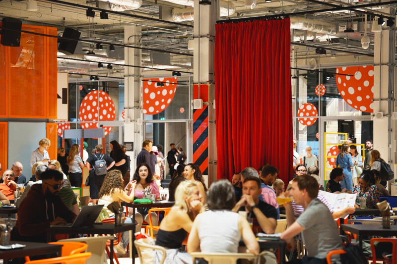 Groups of people sat at tables in a social space