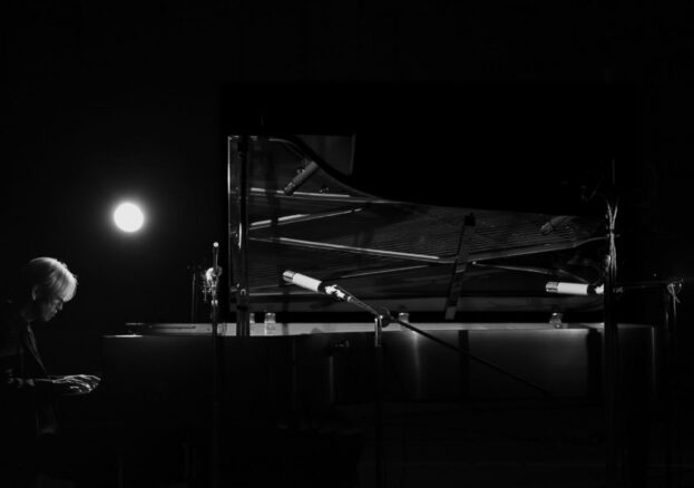 Japanese composer Ryuichi Sakamoto sits at his grand piano whilst performing in the new concert film 'Opus'