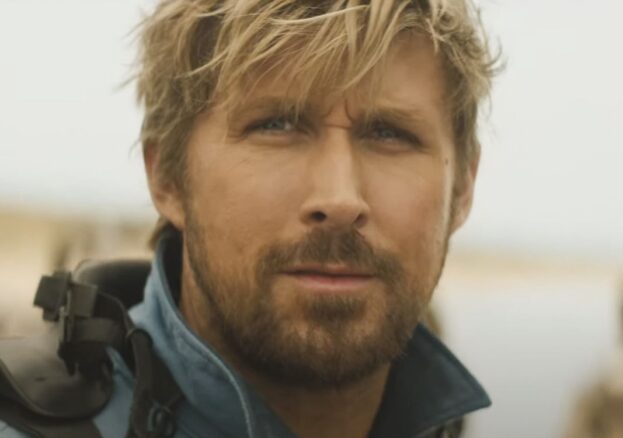 Close up of actor Ryan Gosling who frowns into the distance, hair tossled.