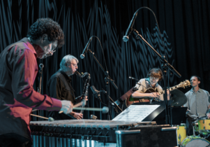 quartet playing with bass clarinet, marimba, electric guitar, and drumkit