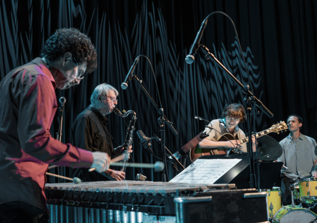 quartet playing with bass clarinet, marimba, electric guitar, and drumkit