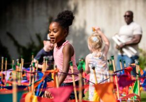 Girl running through flags in garden