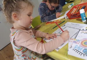 Children sat at a table and colouring 