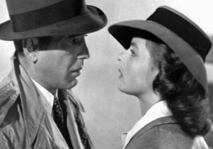 Black and white image of a man and woman looking at each other.