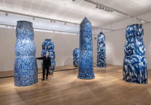 Woman looking and touching large ceramic vessels