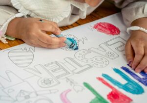 A child colouring in images of Easter eggs and a writing that says Happy Easter Easter Holidays at Central Library