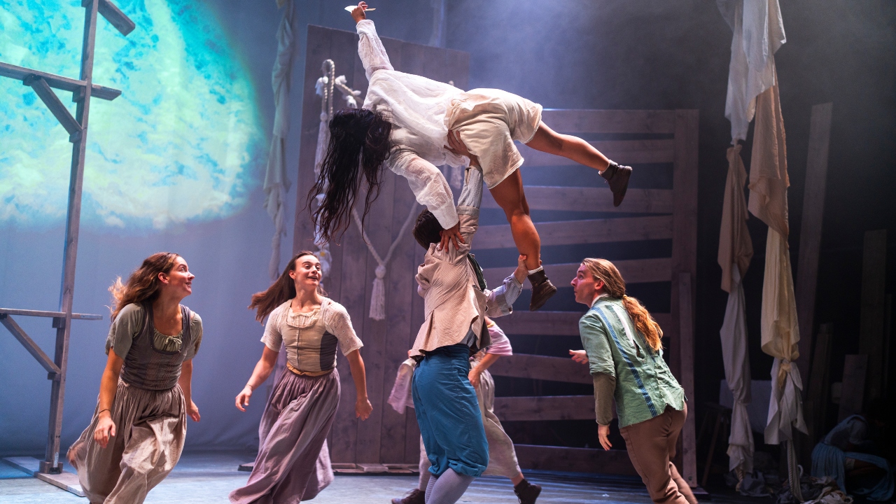 Tess at HOME: Four people dance in a circle, whilst a fifth person holds a woman in the air.