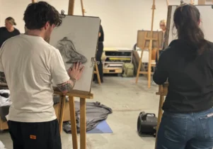 point of view of artists stood at easels drawing the life model