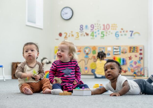 Three babies playing together in a Sure Start Manchester's baby week
