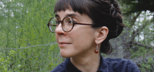 portrait of Lorsung in a dark shirt with dark hair and dark round glasses