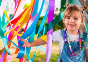 A child playing in some colourful ribbons