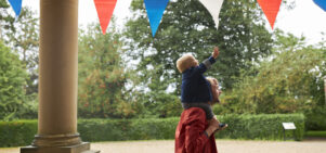 A Lotherton Summer Holiday image of a child reaching for bunting