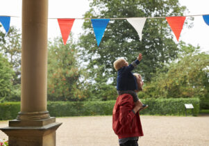 A Lotherton Summer Holiday image of a child reaching for bunting