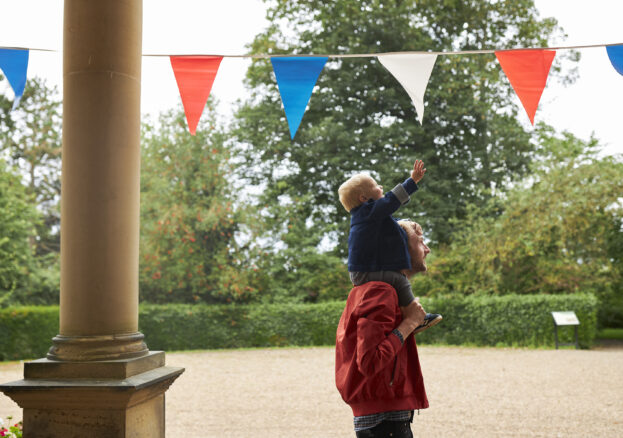 A Lotherton Summer Holiday image of a child reaching for bunting