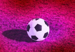 Football against a pink filtered grass pitch