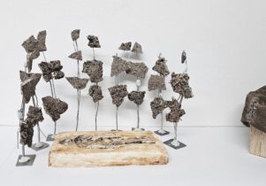 Maquettes of burial grave and metal and earth bound together on a rod a 