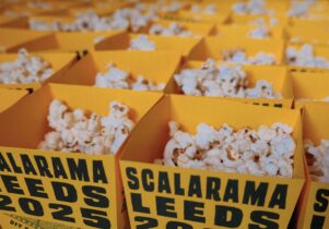 a group of popcorn tubs that are branded yellow saying scalarama leeds 2025