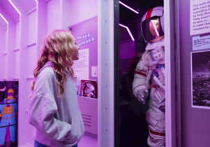 Girl looking at a Space suit in Horrible Science: Cosmic Chaos