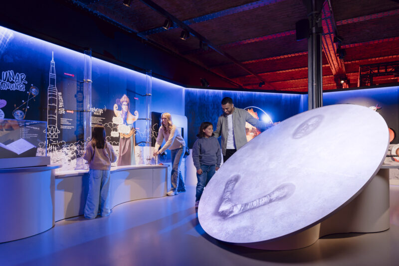 Family looking a giant projection of the moon character in Horrible Science: Cosmic Chaos