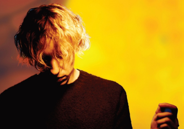 Daniel Avery in front of sun sculpture event poster
