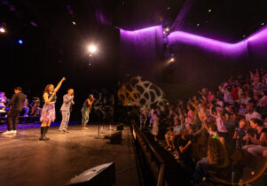 Singers engaging with crowd in theatre