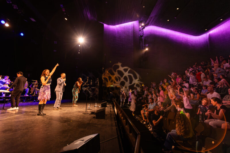 Singers engaging with crowd in theatre
